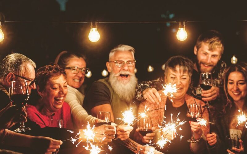 Gruppe fröhlicher Menschen mit Wunderkerzen