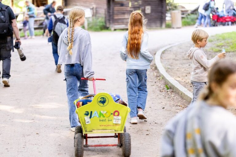Rückenansicht: Mädchen zieht Bollerwagen