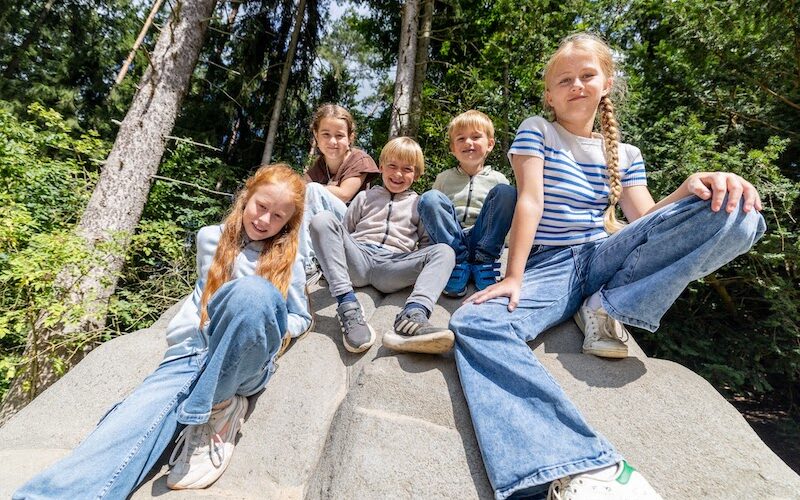 Fünf Kinder auf Felsen sitzend