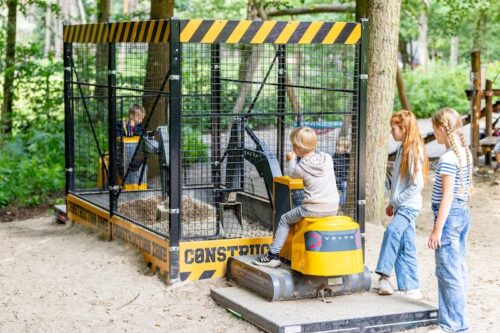 Zwei kleine Jungen auf zwei Baggern, die in einem gemeinsamen Käfig graben