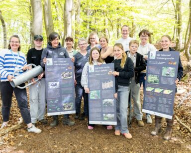 Kinder der IGS Hanstedt und Verantwortliche der Igelpflege Gellersen zeigen die neuen Infotafeln für den Igelpfad