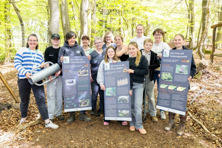 Kinder der IGS Hanstedt und Verantwortliche der Igelpflege Gellersen zeigen die neuen Infotafeln für den Igelpfad